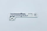 White plastic button gauge with white linen button in calipers