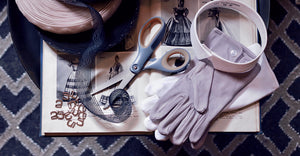 Men's cotton gloves, detachable collar, silicone elastic, and quick rig shoe hooks scattered on historic dress-making guide