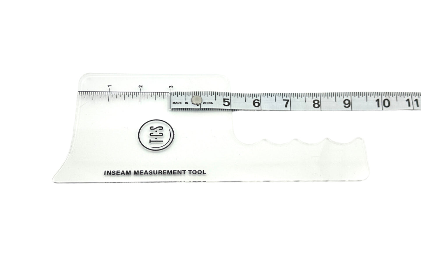 A clear plastic inseam measurement tool with attached measuring tape