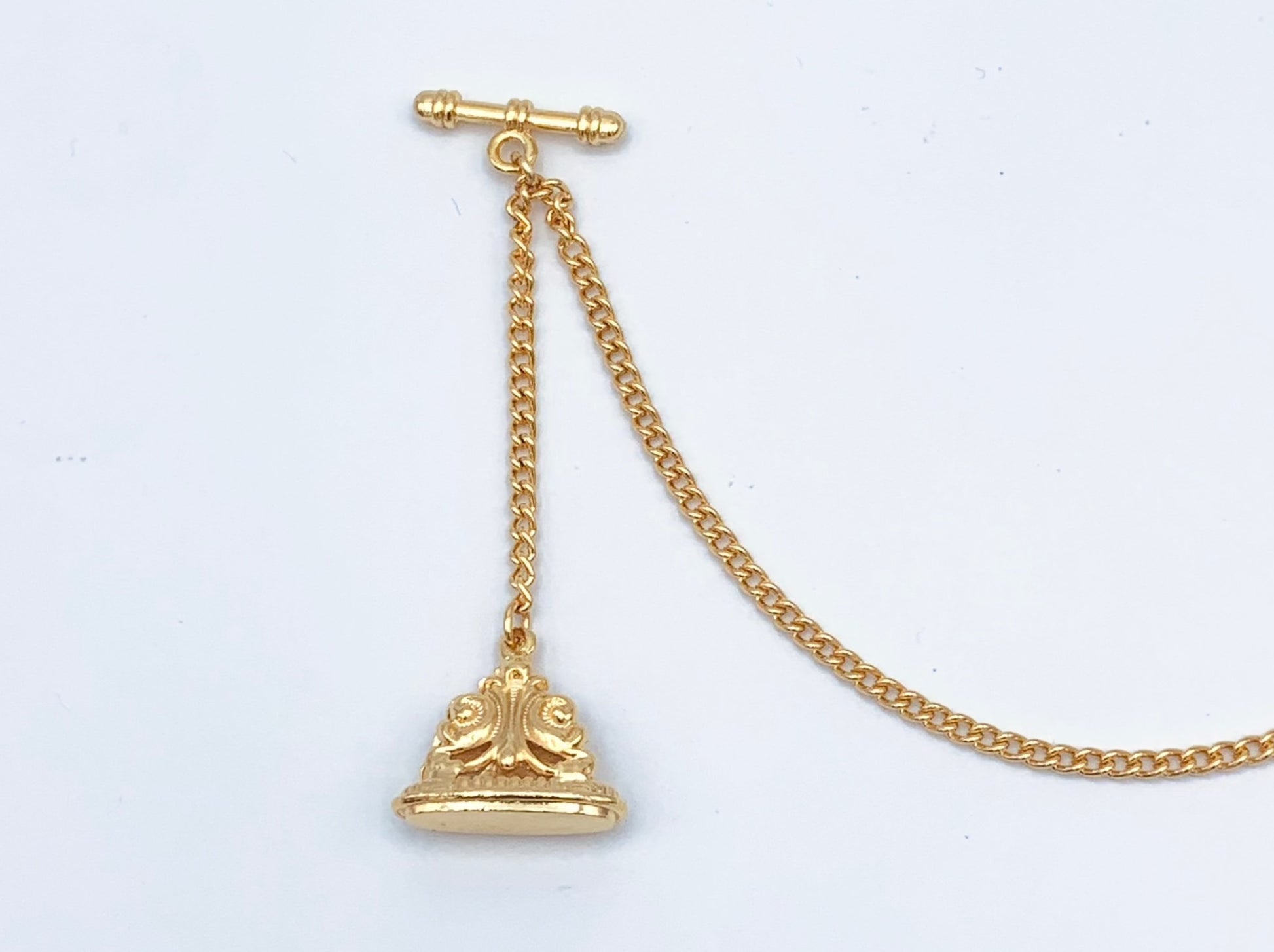 Watch fob in goldtone with bar to slip into button hole and on goldtone chain