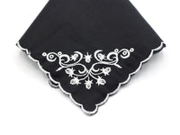 black handkerchief with white scalloped edge and white embroidered corner