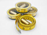 Artful stack of Plumb tape measures coiled in plastic cases